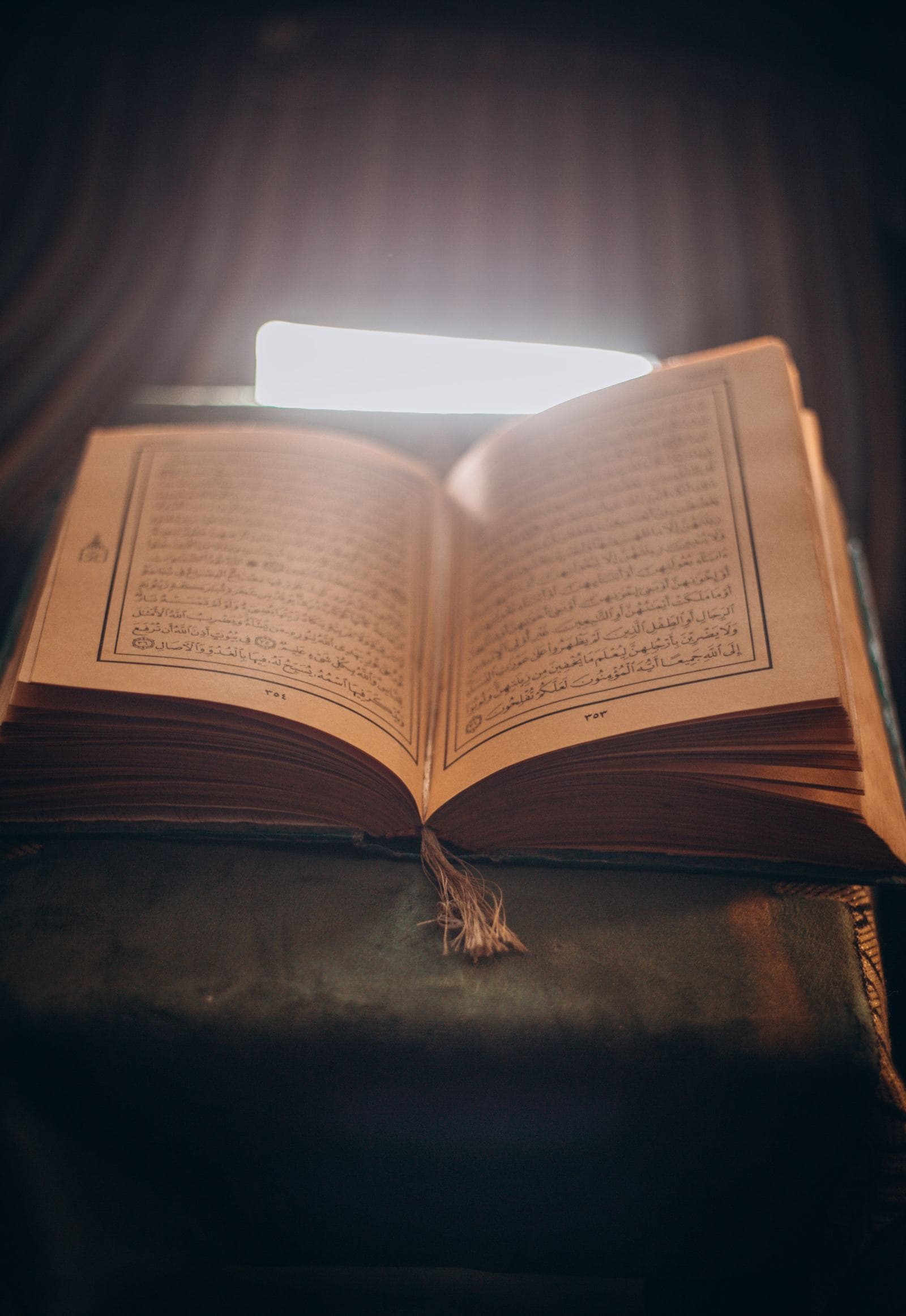 Open Quran glowing in warm light