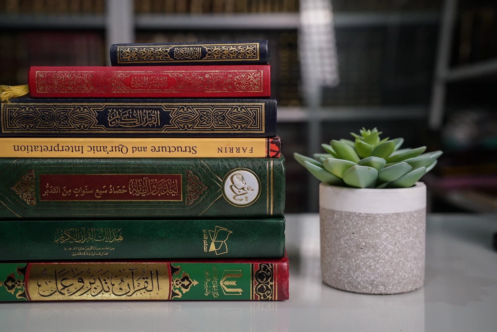 Stack of Islamic study books beside the Quran